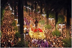Een processie met een praalwagen tussen de mensen